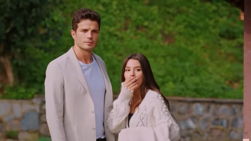 Zeynep zasłania usta dłonią, zszokowana. Obok niej stoi Ege.