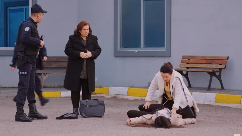 Cavidan pochyla się nad nieprzytomną Bahar. Obok stoją Naciye i policjant.