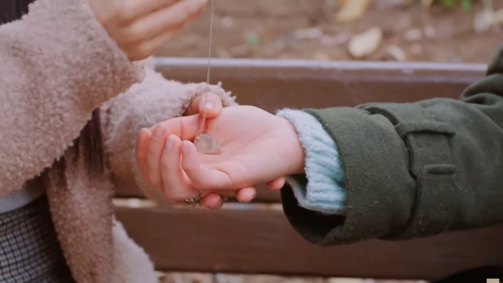 Bahar kładzie na dłoni Sili wisiorek.