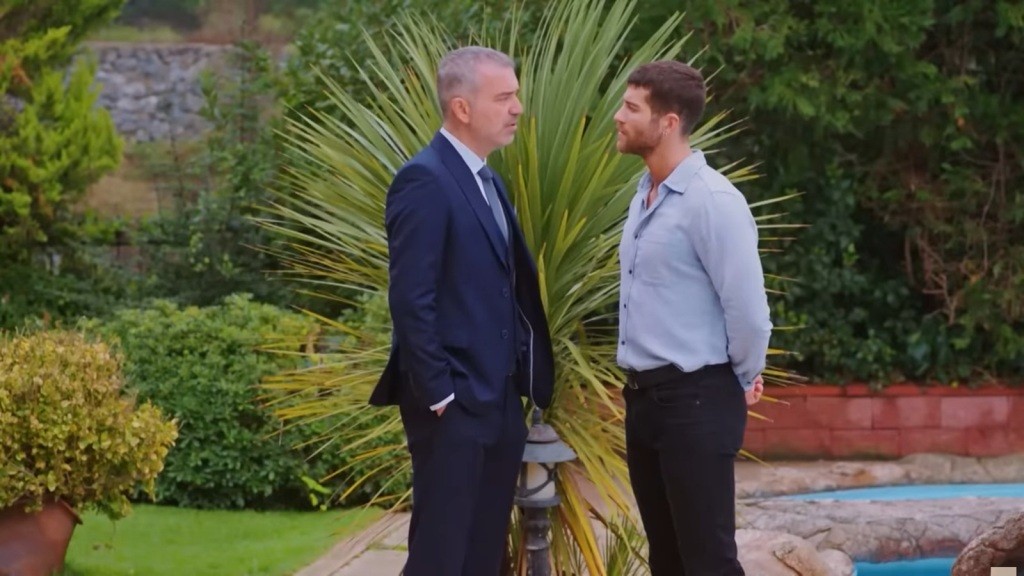 Bulent i Cihan stoją twarz w twarz w ogrodzie.