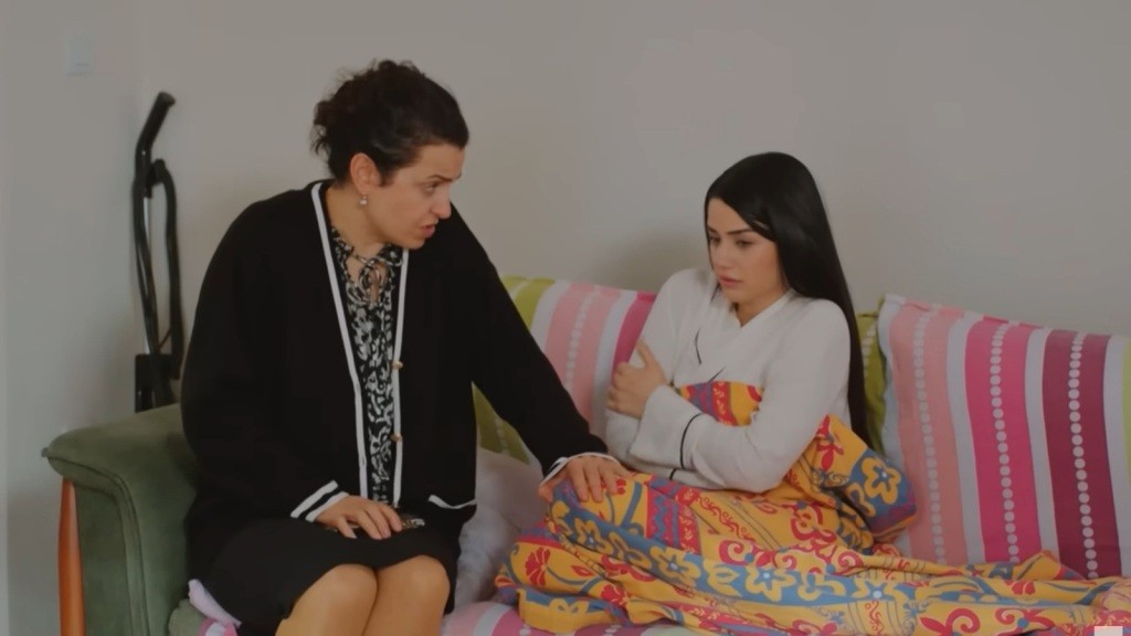 Cavidan siedzi przy Bahar, która otula się kocem.