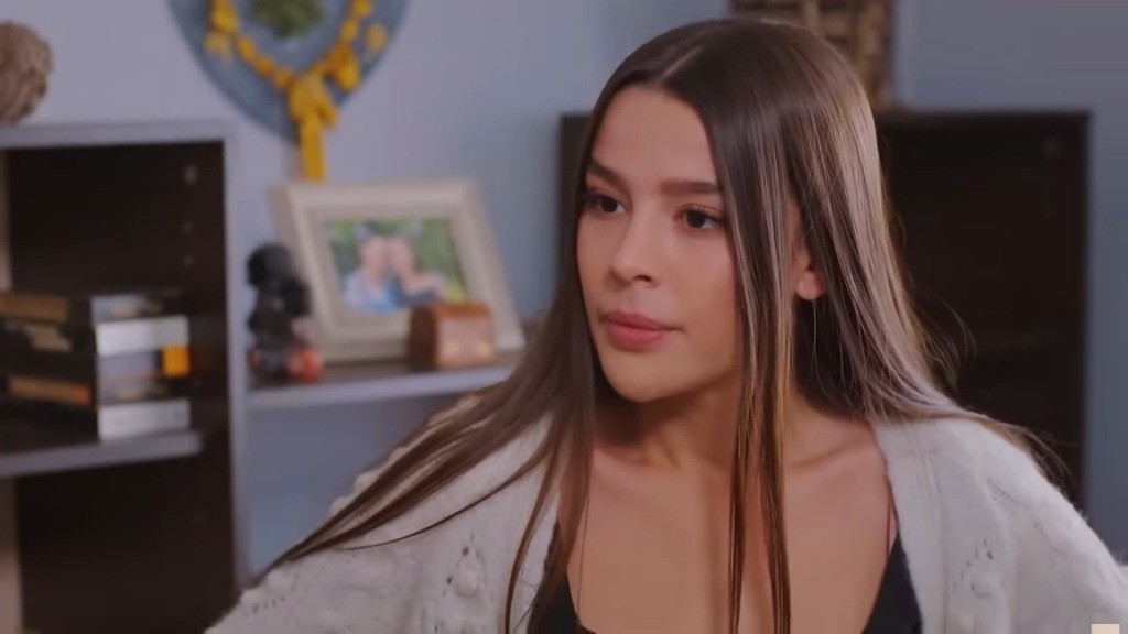 Zeynep przybiera poważny wyraz twarzy.