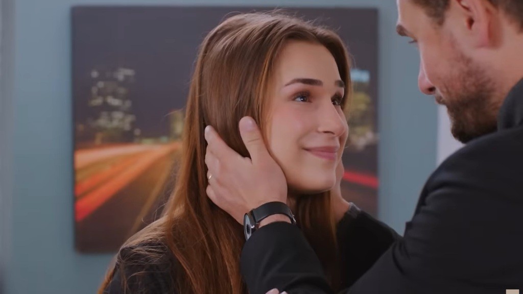 Sila patrzy w oczy Kuzeya. Jego dłonie dotykają jej włosów i policzków.