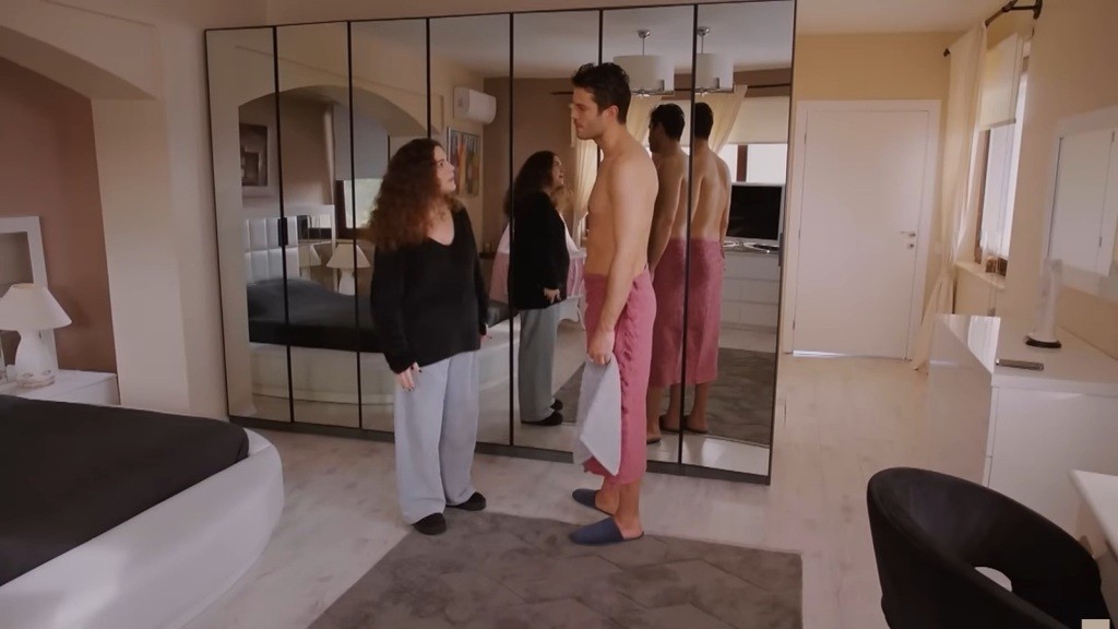 Ege stoi przed Melis, owinięty jedynie ręcznikiem przewiązanym w pasie. Ona patrzy na niego gniewnie.