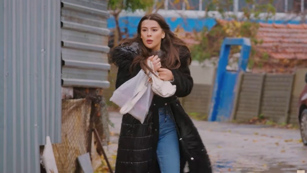 Zeynep idzie drogą, przestraszona.