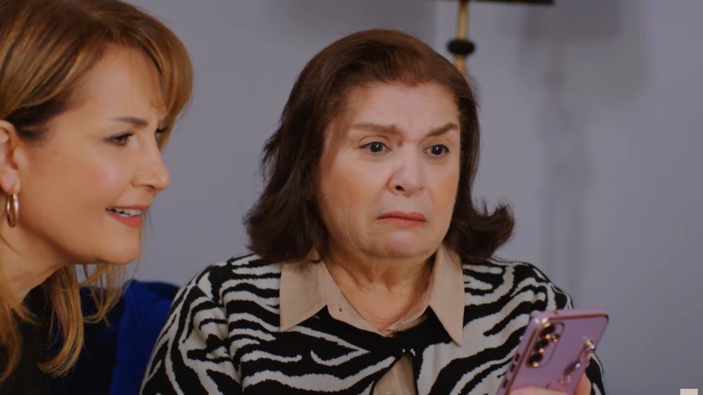 Naciye z przerażoną miną trzyma telefon w ręku. Feraye siedzi przy niej.