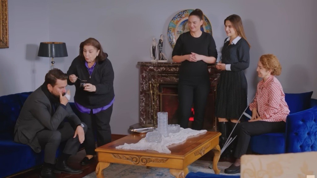 Naciye namawia Kuzeya do zjedzenia melasy. Sila, Yildiz i Hulya patrzą na to z uśmiechem.