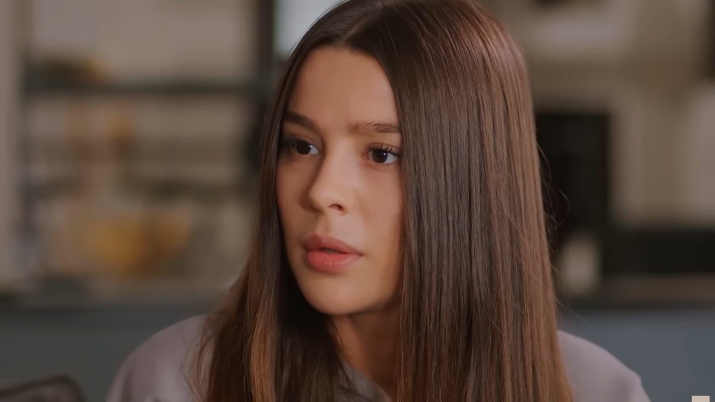 Zbliżenie na osłupiałą twarz Zeynep.