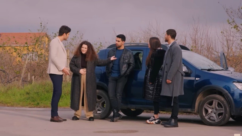 Ege, Melis, Gokhan, Zeynep i Cihan przy granatowym samochodzie.