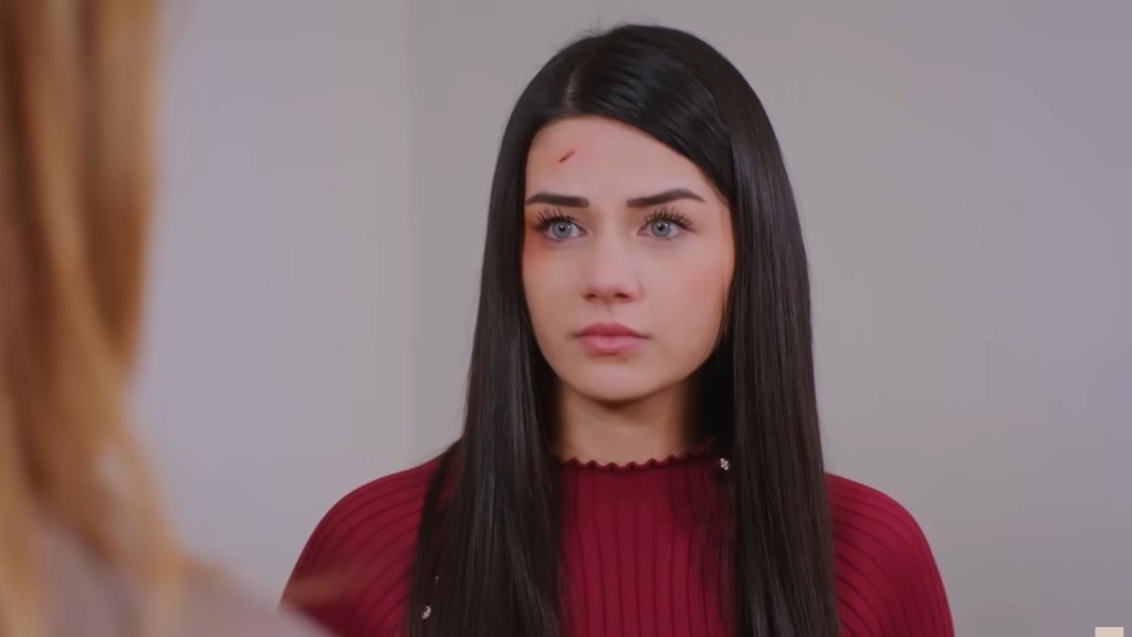 Melis wydaje się niepewna, gdy spogląda na Feraye, stojącą przed nią.