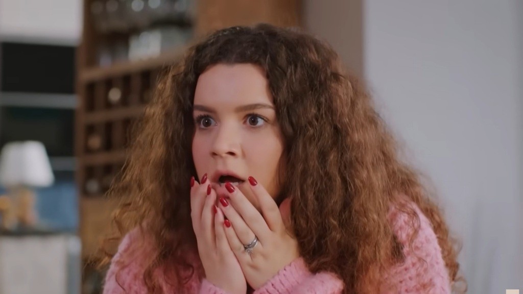 Melis jest zszokowana. Unosi dłonie do ust.