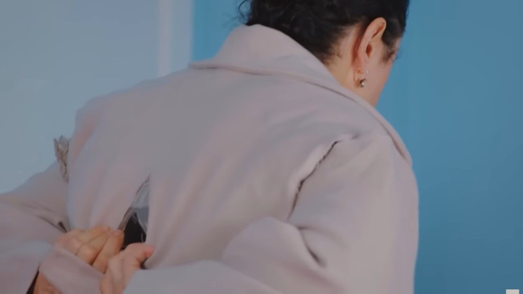 Płaszcz Feraye pęka na plecach, gdy Cavidan zakłada go na siebie.