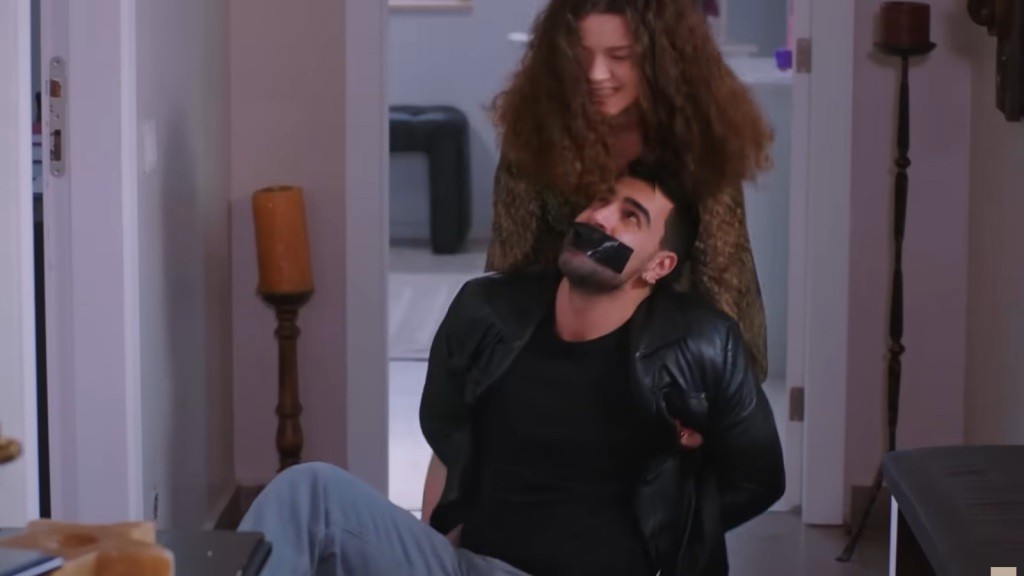 Melis wysila się, ciągnąc związanego Gokhana.