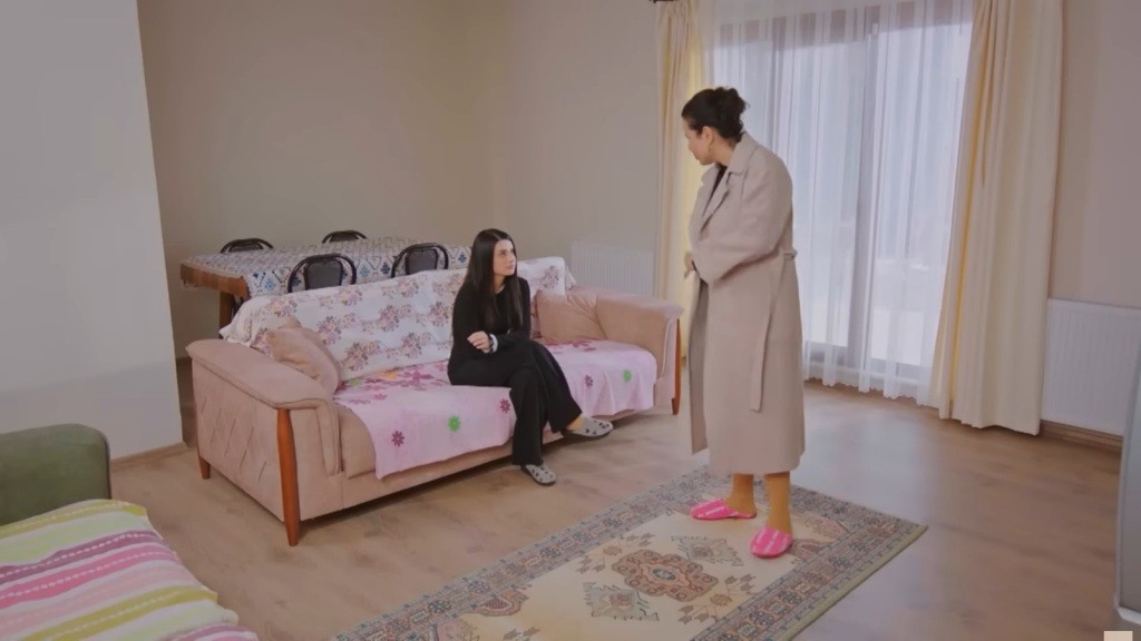 Bahar siedzi na kanapie i patrzy, jak Cavidan paraduje po pokoju w płaszczu Feraye.