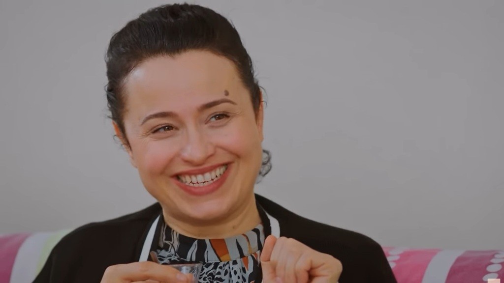 Cavidan uśmiecha się szeroko, jakby właśnie usłyszała najlepszy żart.