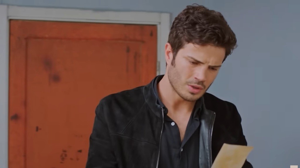 Ege patrzy na zdjęcie, mrużąc oczy.