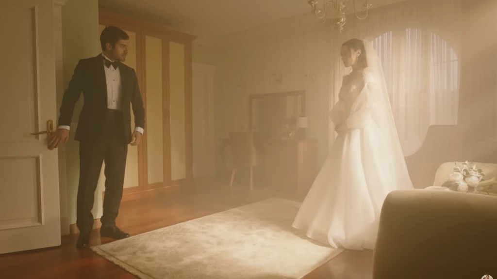 Halil wchodzi do pokoju, patrząc na Zeynep ubraną w suknię ślubną.