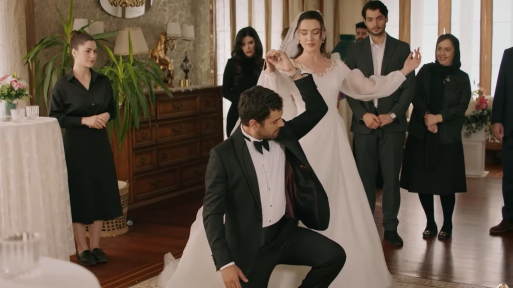 Halil klęczy na jednym kolanie, tańcząc z Zeynep.