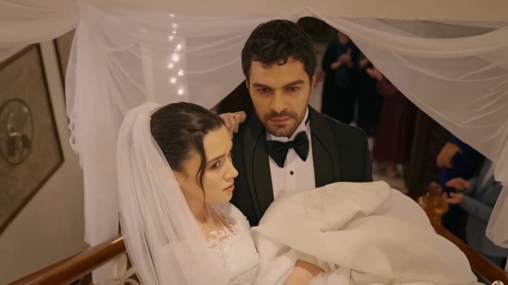 Halil niesie Zeynep na rękach, wchodząc po schodach z gracją.