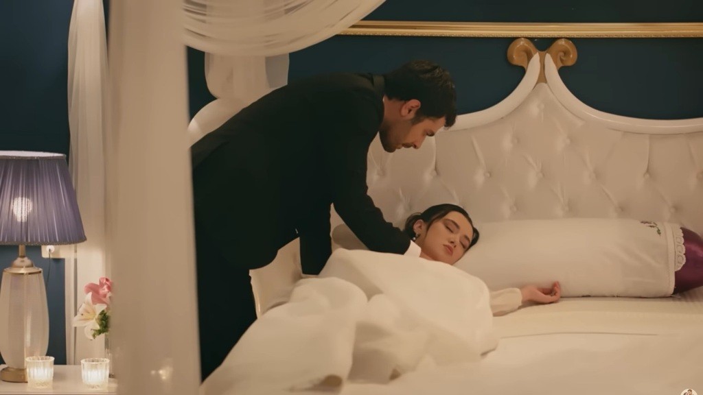 Zeynep zasnęła na łóżku w sukni ślubnej. Halil pochyla się nad nią.