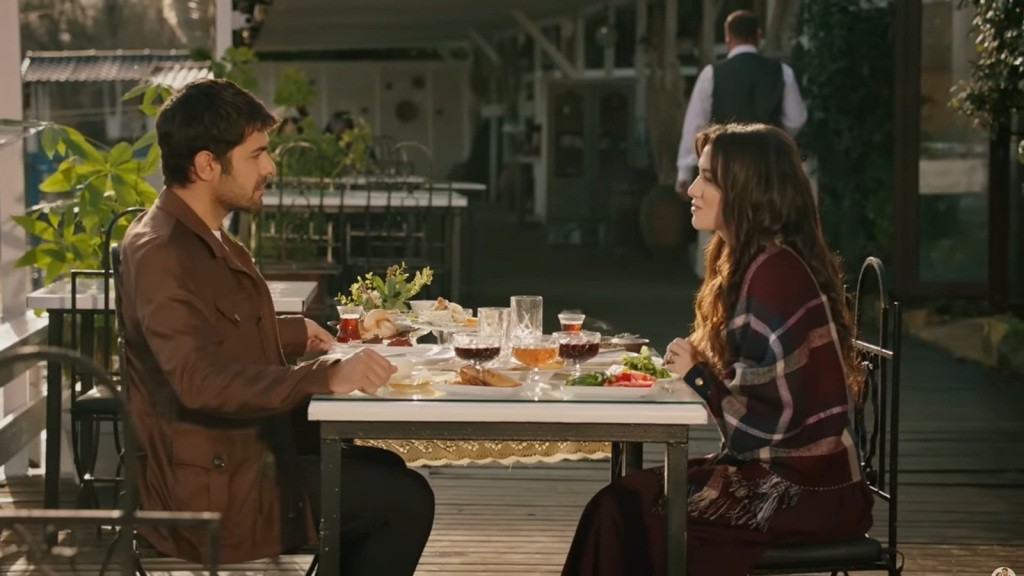 Halil i Zeynep siedzą przy stoliku w restauracji.