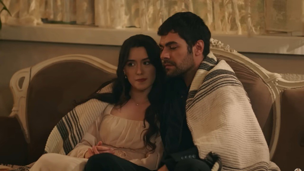 Halil i Zeynep siedzą na sofie, otuleni kocem.