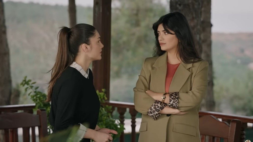 Gozde patrzy na Arzu, stojąc ze skrzyżowanymi rękami.