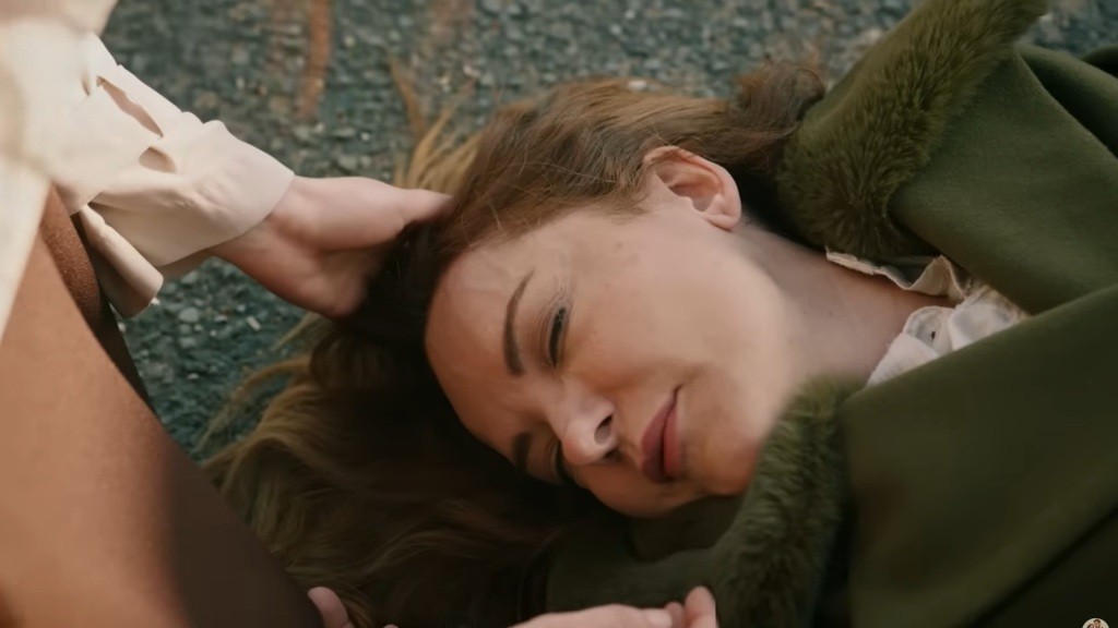 Songul leży bez ruchu na jezdni, a Zeynep delikatnie dotyka jej głowy.