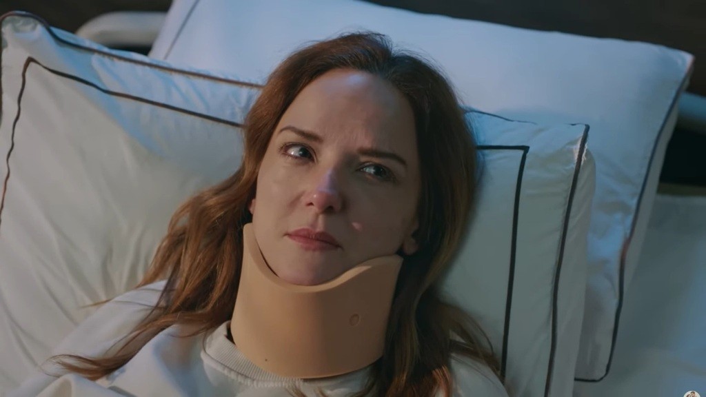 Songul leży na szpitalnym łóżku, z gorsetem ortopedycznym stabilizującym jej szyję.