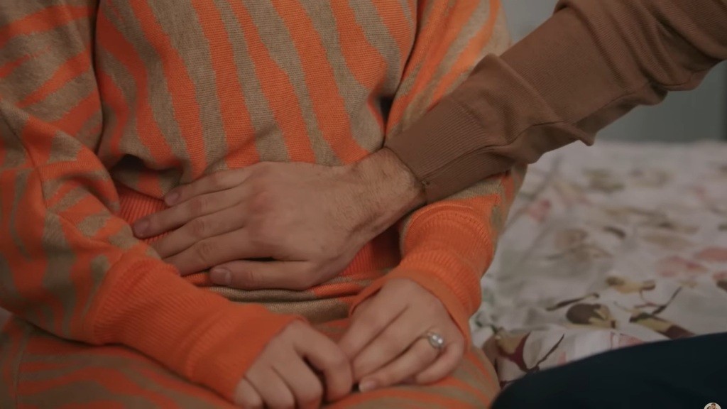 Zbliżenie na dłoń Erena, spoczywającą na brzuchu Selmy.