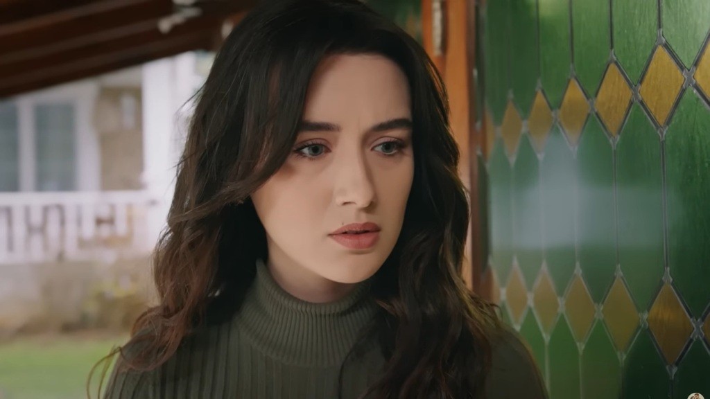 Zeynep nasłuchuje, stojąc przy drzwiach pracowni. Jej twarz wyraża poruszenie.