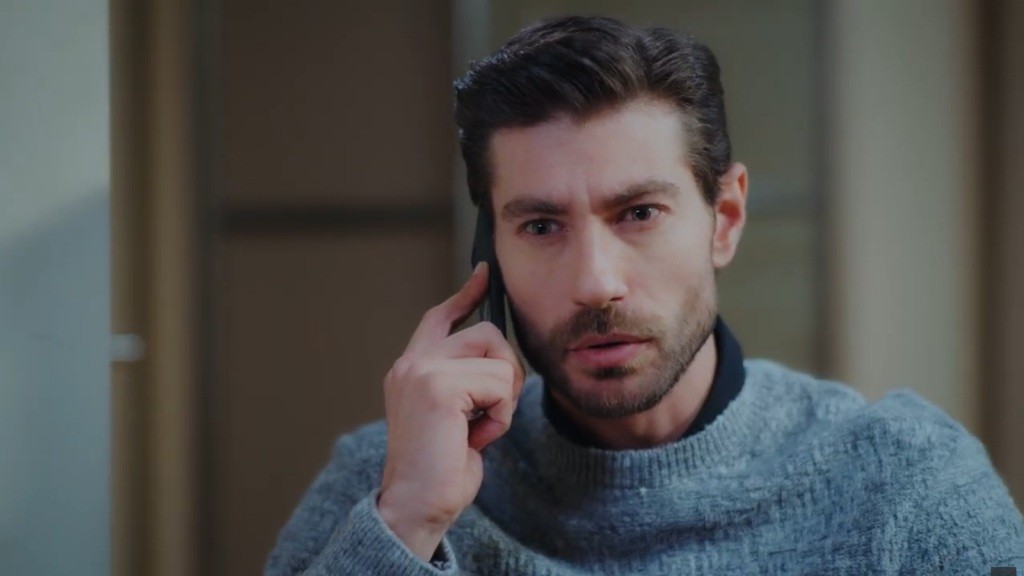 Sinan rozmawia przez telefon. Jego twarz wyraża poruszenie.