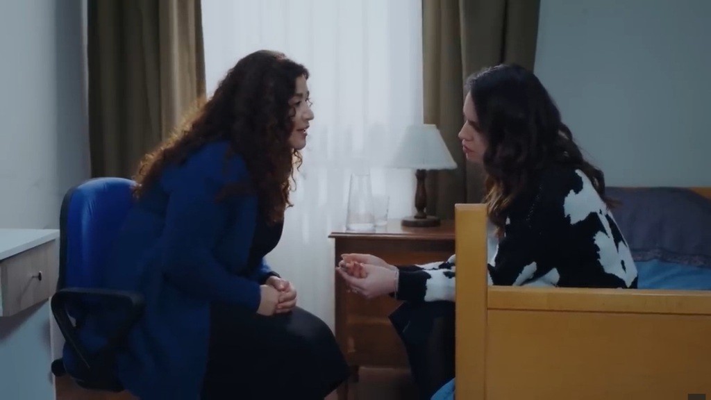 Cansel i Pelin rozmawiają w pokoju, siedząc naprzeciwko siebie.