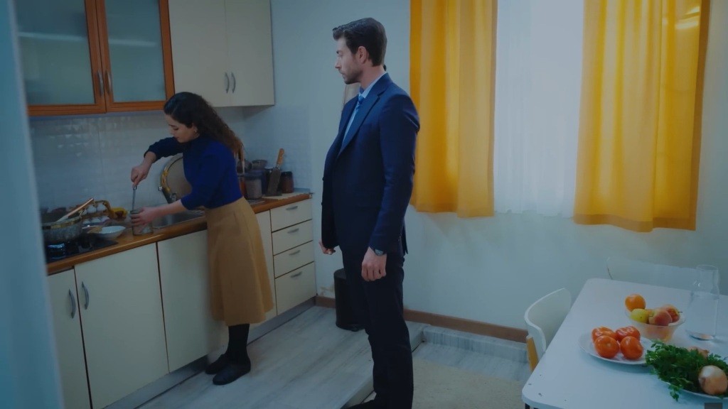 Sinan obserwuje, jak Aynur otwiera puszkę nożem.