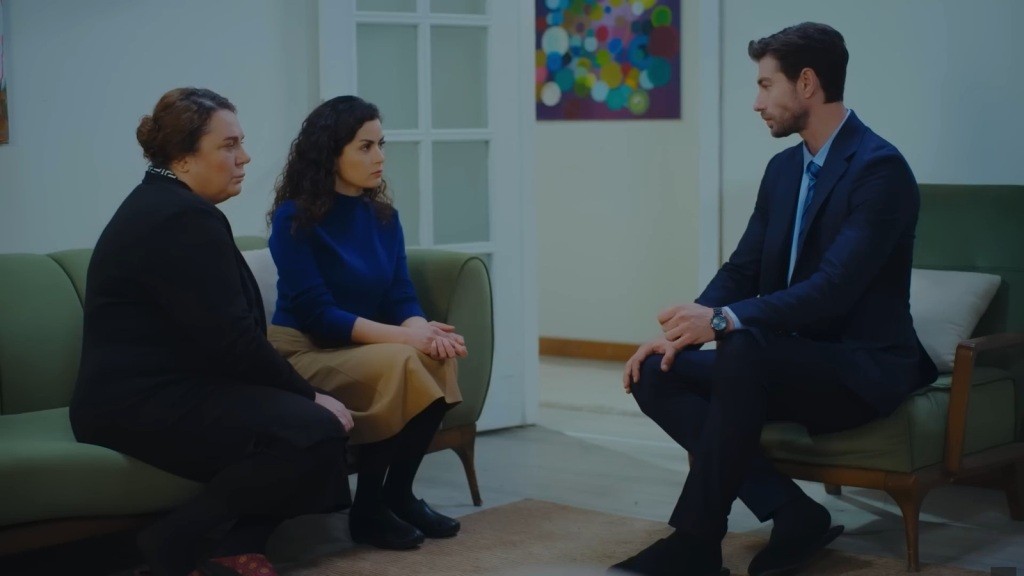Sinan siedzi naprzeciwko Adalet i Aynur.
