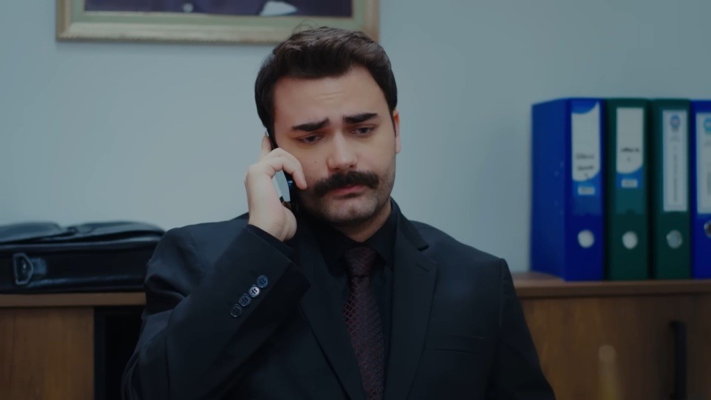 Prokurator Baran rozmawia przez telefon.