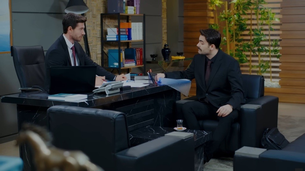 Sinan i Baran siedzą naprzeciwko siebie.