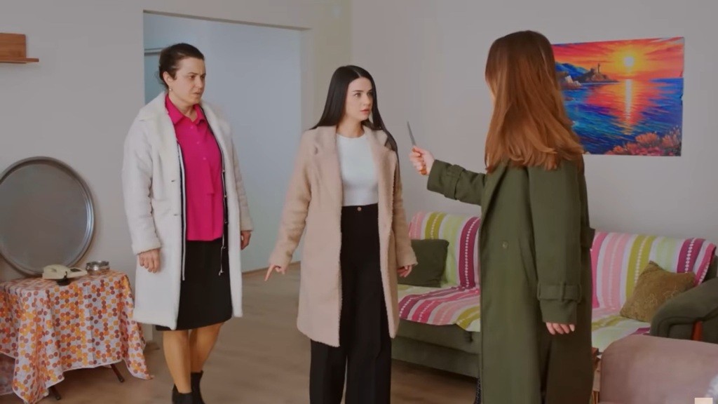 Sila trzyma w ręku nóż, stojąc przed Bahar i Cavidan.