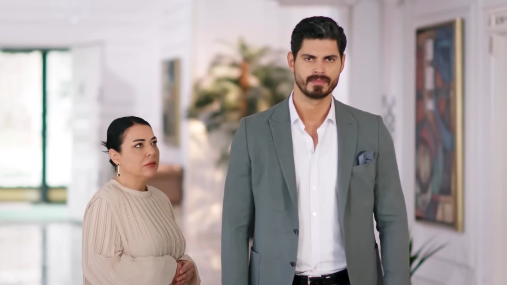 Mukadder stoi obok syna, który odwrócił się do niej plecami.