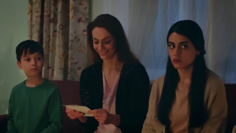 Derya trzyma w rękach zdjęcie i wpatruje się w nie z uśmiechem Obok niej siedzą Emir i Hancer.