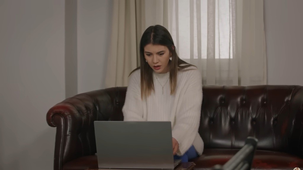 Selma zdumionym wzrokiem wpatruje się w ekran laptopa.