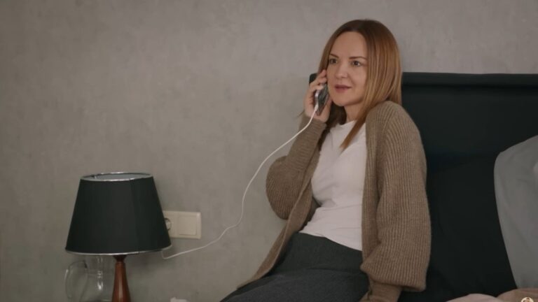 Songul rozmawia przez podłączony do ładowarki telefon.