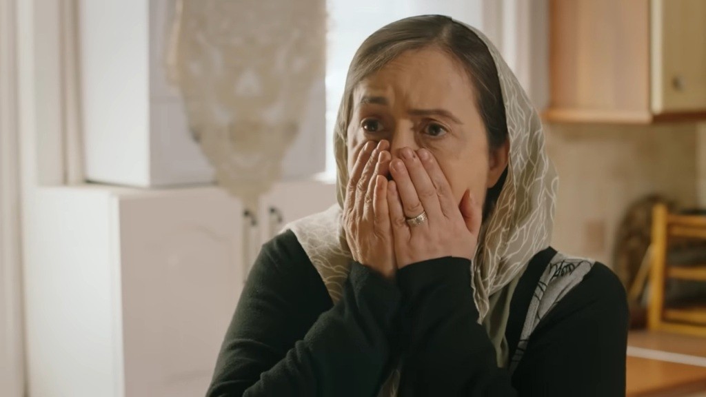 Kiymet chowa twarz w dłoniach.