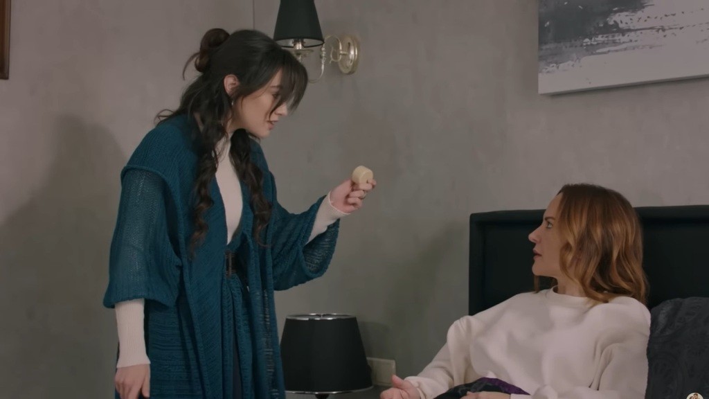 Zeynep pokazuje Songul opakowanie kremu.