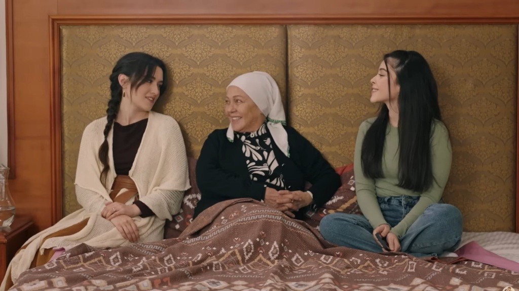Zumrut leży w łóżku, otoczona przez siedzące obok niej Zeynep i Merve.