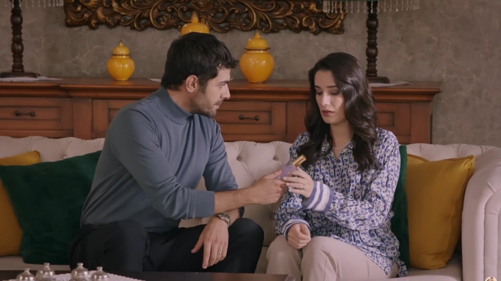 Halil podaje Gulhan flakon perfum.