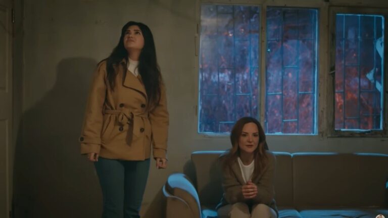 Gozde rozgląda się z obrzydzeniem po kryjówce Songul, podczas gdy ona sama siedzi na kanapie.