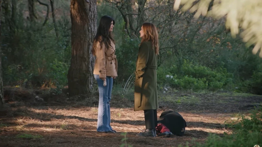 Zeynep i Songul stoją twarzą w twarz. Obok nich, na ściółce, leży nieprzytomna Zeynep.