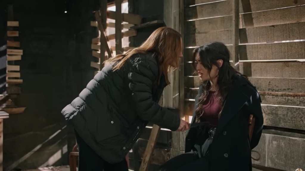 Songul trzyma ostrze noża przy brzuchu przywiązanej do krzesła Zeynep.