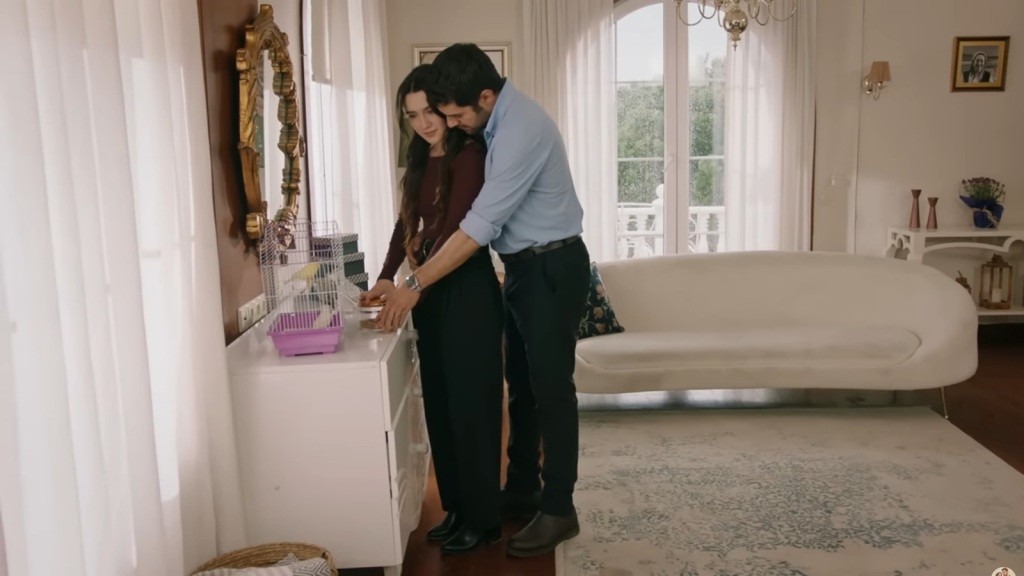 Halil stoi za Zeynep i obejmuje ją w talii.